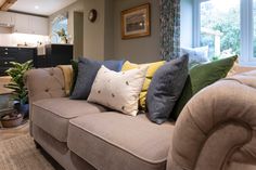 a living room filled with furniture and lots of pillows