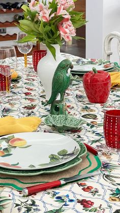 the table is set with plates, cups and vases