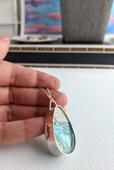 This necklace is an unique piece of art that you can wear! I made it with sand that I've collected from beach trips to the beautiful coasts of North and South Carolina and a crystalline blue resin. It is framed in an elegant handmade Sterling Silver bezel. It hangs from a 17 inch sterling silver chain. It measures 0.875 inches wide by 1.375 inches tall, and 3/8 inches in depth. It weighs under 1 oz - incredibly light! The length of the chain can be adjusted, just leave me a note at check out and Wood And Resin Jewelry, Jewellery Resin, Sand Necklace, Silver Drop Necklace, Wood Resin Jewelry, Jewelry Wood, Moon Phases Necklace, Sterling Silver Stacking Rings, Wood And Resin