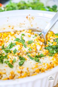 a casserole dish filled with corn and cheese, garnished with parsley