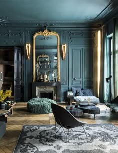 a living room filled with lots of furniture and walls painted teal green in an ornate style