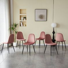 four pink chairs are lined up against the wall