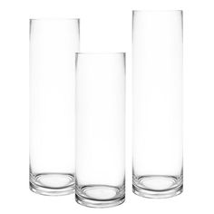 three tall glass vases sitting next to each other on a white background, one empty and one half filled with water