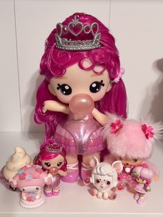 there is a doll with pink hair and many other toys