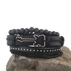 This guitar bracelet set complements your love for music. The all black bracelets are versatile and can be worn with any of your outfits. You can wear the bracelets together as a set or each one separately to create a different everyday. Every set is handmade with care. Product Information *Set comes with 3 bracelets *Material: leather/PU leather *Metals Type: alloy *Clasp Type: sliding knots *Adjustable Length: around 7 - 8.5 inches Black Band Wristband For Concerts, Black Punk Wristband For Concert, Casual Black Bracelets For Festival, Black Punk Bracelets For Festival, Black Rock Wristband For Concerts, Black Rock Style Bracelets For Festival, Black Punk Festival Bracelets, Black Rock Style Wristband For Concerts, Adjustable Punk Wristband For Concerts