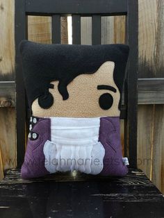 a pillow that has been made to look like elvis presley sitting on a wooden chair