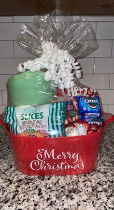 a red bucket filled with lots of candy and candies sitting on top of a counter