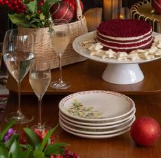 a table topped with plates covered in cake next to wine glasses and vases filled with flowers