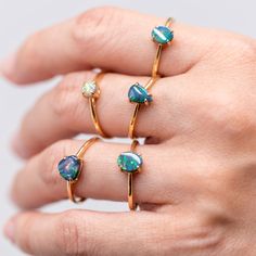 a woman's hand with three rings on it and one has an opal stone