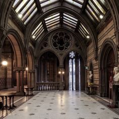 the inside of a large building with many windows and statues on either side of it