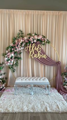 a wedding stage decorated with pink flowers and greenery