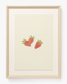 two strawberries are shown on a white background in a wooden frame, with the image framed above it