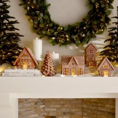 a fireplace mantle decorated with christmas decorations and lit candles