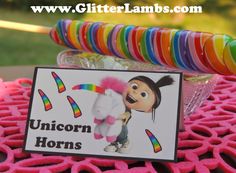 there is a sign that says unicorn horns on it and some candy sticks in the background