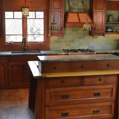 a kitchen with wooden cabinets and green tile backsplash, wood flooring and an island