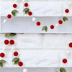 red and white pom - poms hanging from the side of a brick wall