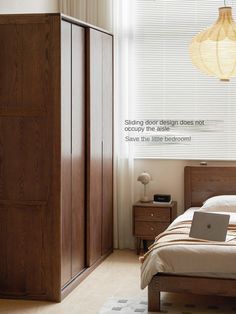 a bed room with a laptop computer on top of it next to a dresser and window