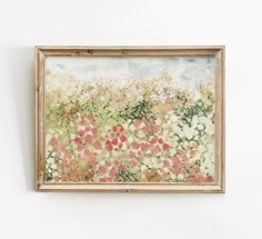 a painting hanging on the wall in front of a white wall with red and yellow flowers