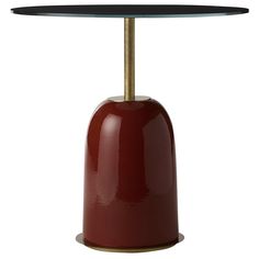 a red table with a black top and gold base on white backgrounnd