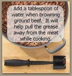 a bowl filled with food sitting on top of a table next to a spatula