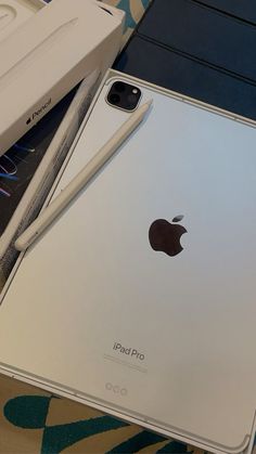 an apple ipad sitting on top of a table next to a box with the lid open