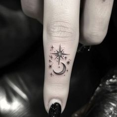 a person with a star and moon tattoo on their finger