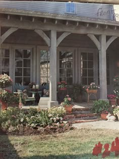 a porch with potted plants and flowers on it