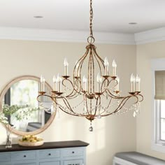 a chandelier hanging from the ceiling in a room with a dresser and mirror