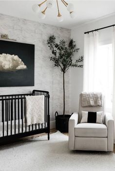 a baby's room with a crib, chair and painting on the wall