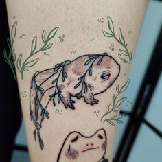 a tattoo on the leg of a woman with an animal and plants around her legs