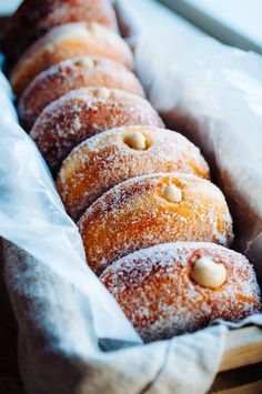 a bunch of doughnuts that are sitting in a basket on a table together