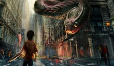 a man walking down a city street next to tall buildings with giant snakes on them