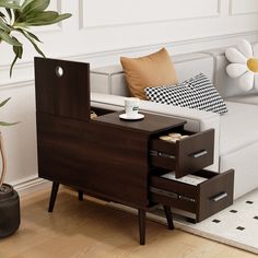 a living room with a couch, coffee table and flower pot on the floor next to it