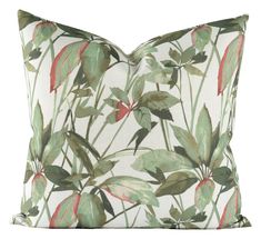 a white pillow with green and red leaves on it