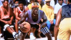 a man holding a basketball while standing next to other people