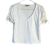 Ruched Puff Sleeve V-Neck Cropped Top M New Color: White Cute Casual And Trendy Short Sleeve Tee Shirt Crop Top With Ruched Tie Sleeves And V Neck. Pairs Well With Almost Anything. Pair With Jeans And Sneakers For A Quick On Trend Comfortable And Casual Look. Short Sleeves V-Neck Ruched Sleeves Bow On Sleeves Stretchy Flat Lay Measurements Are Approximate; Length: 18” Inches Chest: 15.5” Inches One Way Across Before Stretch Brand New, Washed But Never Worn Ruched T-Shirt Cropped Top With Bow Tie American Eagle Crop Top, Shirt Crop Top, Top With Bow, Spaghetti Strap Crop Top, T Shirt Crop Top, Look Short, Tie Shorts, White Halter Maxi Dress, Tie Sleeve