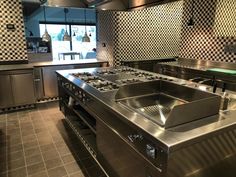 a commercial kitchen with stainless steel appliances and checkered walls