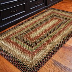 a rug on the floor in front of a dresser with drawers and cabinets behind it