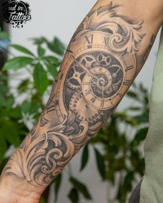 a man's arm with a clock tattoo on it