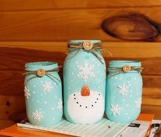 three mason jars with snowmen painted on them