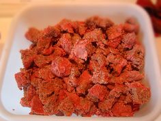 a white bowl filled with red food on top of a table