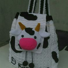 a crocheted purse with a cow on the front and pink tongue sticking out