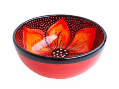 a red bowl with an orange flower painted on the side and black trim around it