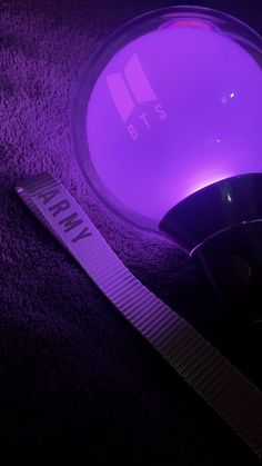 a purple object is sitting on the floor next to a measuring tape and a tag