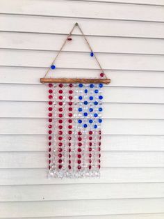 an american flag made out of beads hanging from a wooden frame on the side of a building