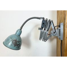 an old fashioned light is attached to the wall with a clip on it's arm