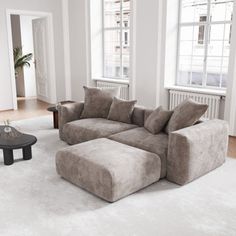 a living room filled with furniture and white carpeted flooring on top of a hard wood floor