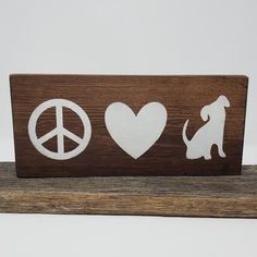 a wooden sign with peace, love and dogs on it