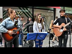 two people are singing and playing music on the street