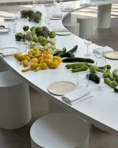 A minimalistic, modern dining setup featuring a sleek white table garnished with fresh produce. Perfect for eco-conscious couples, this tablescape combines natural elements with contemporary design.